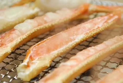 網で焼き上げるかにの脚